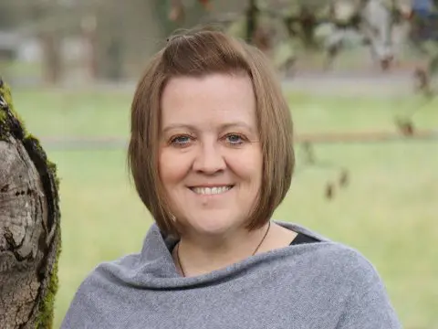 A woman with short hair is smiling for the camera.