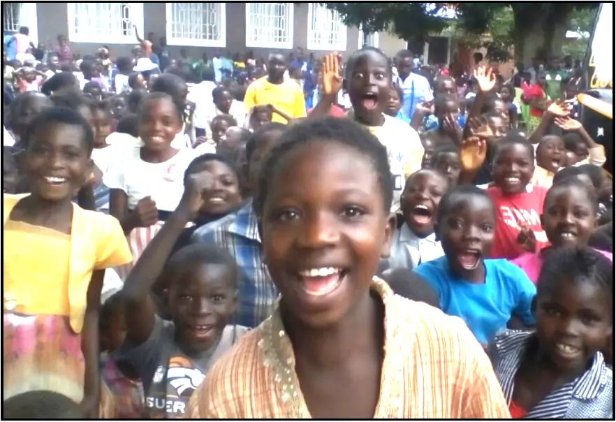 A group of children standing together in front of a building.