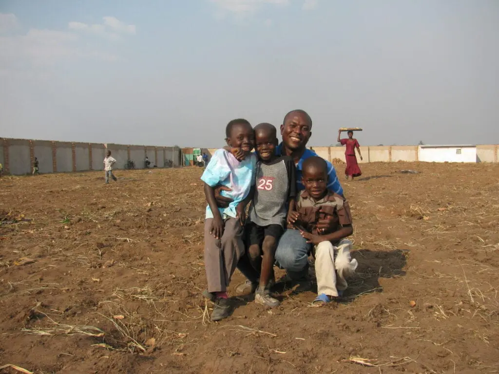 A group of people posing for the camera in an open field.