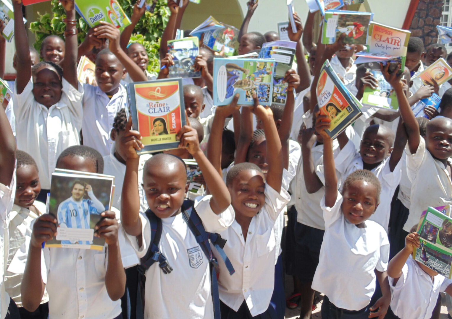 Kids in uniform raising their books
