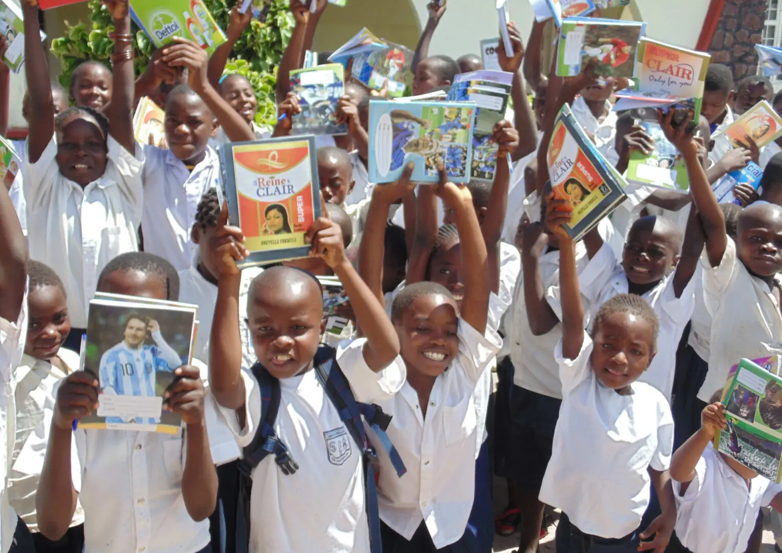 A group of children holding up books in the air.