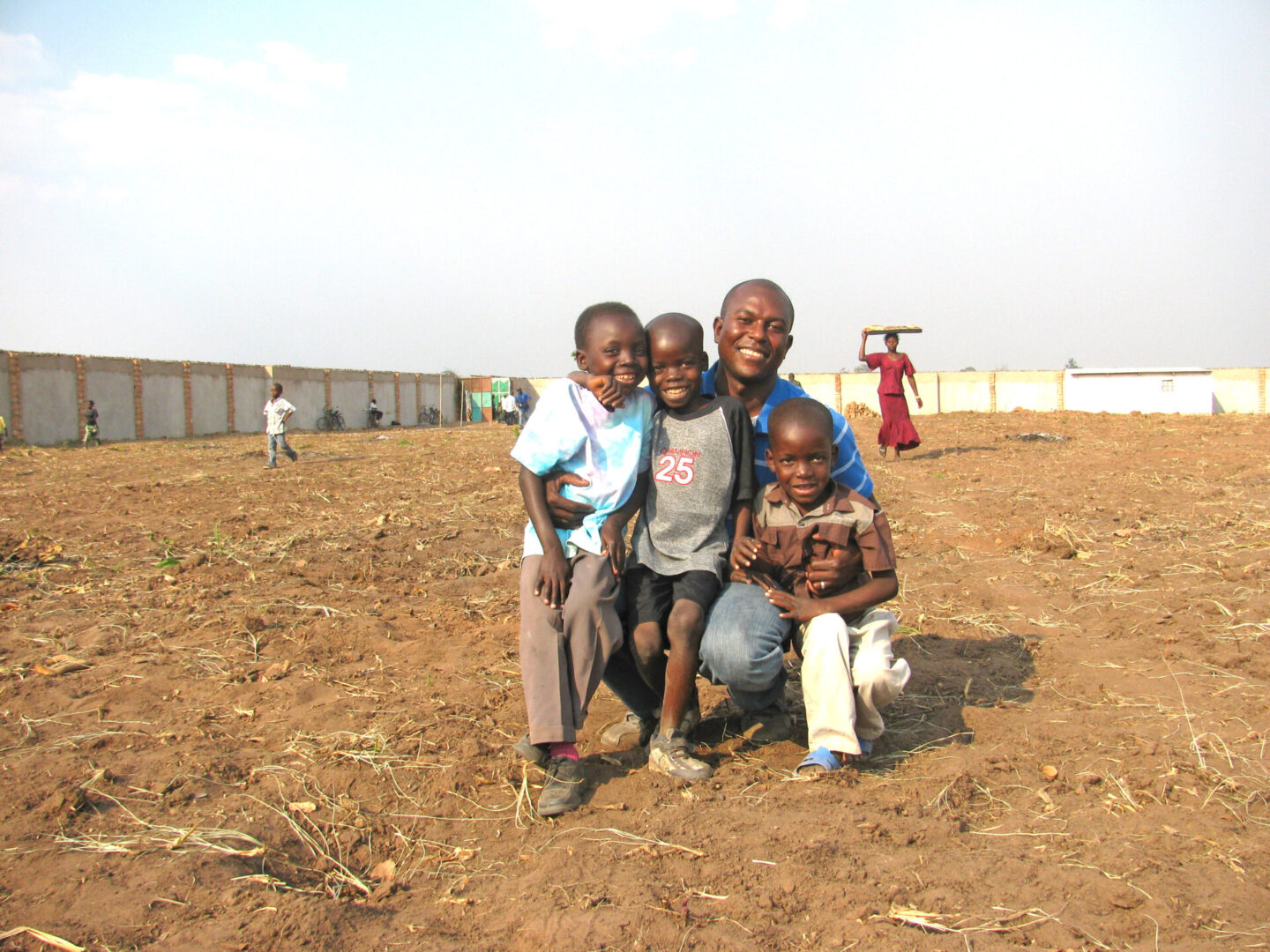 A group of people posing for the camera in an open field.