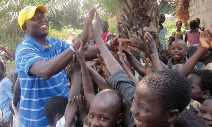 A group of people reaching up for something.