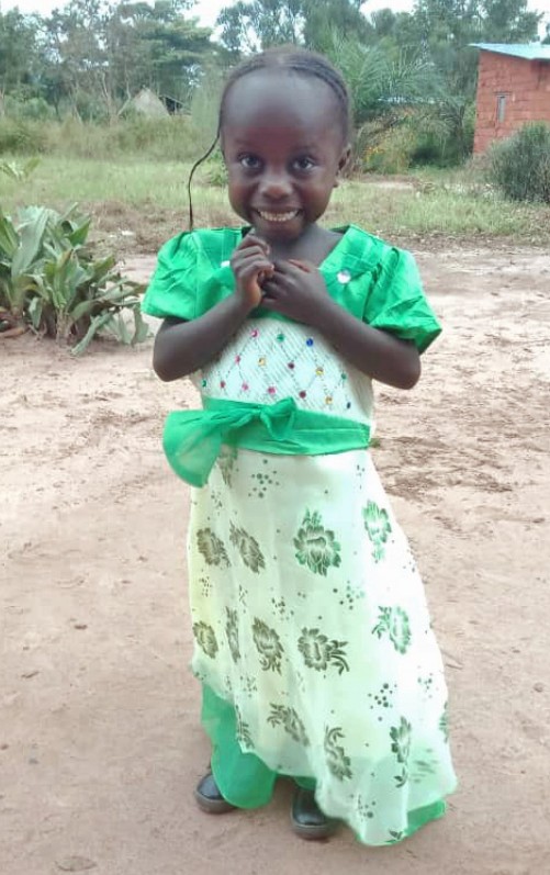 A young girl in green dress holding an umbrella.