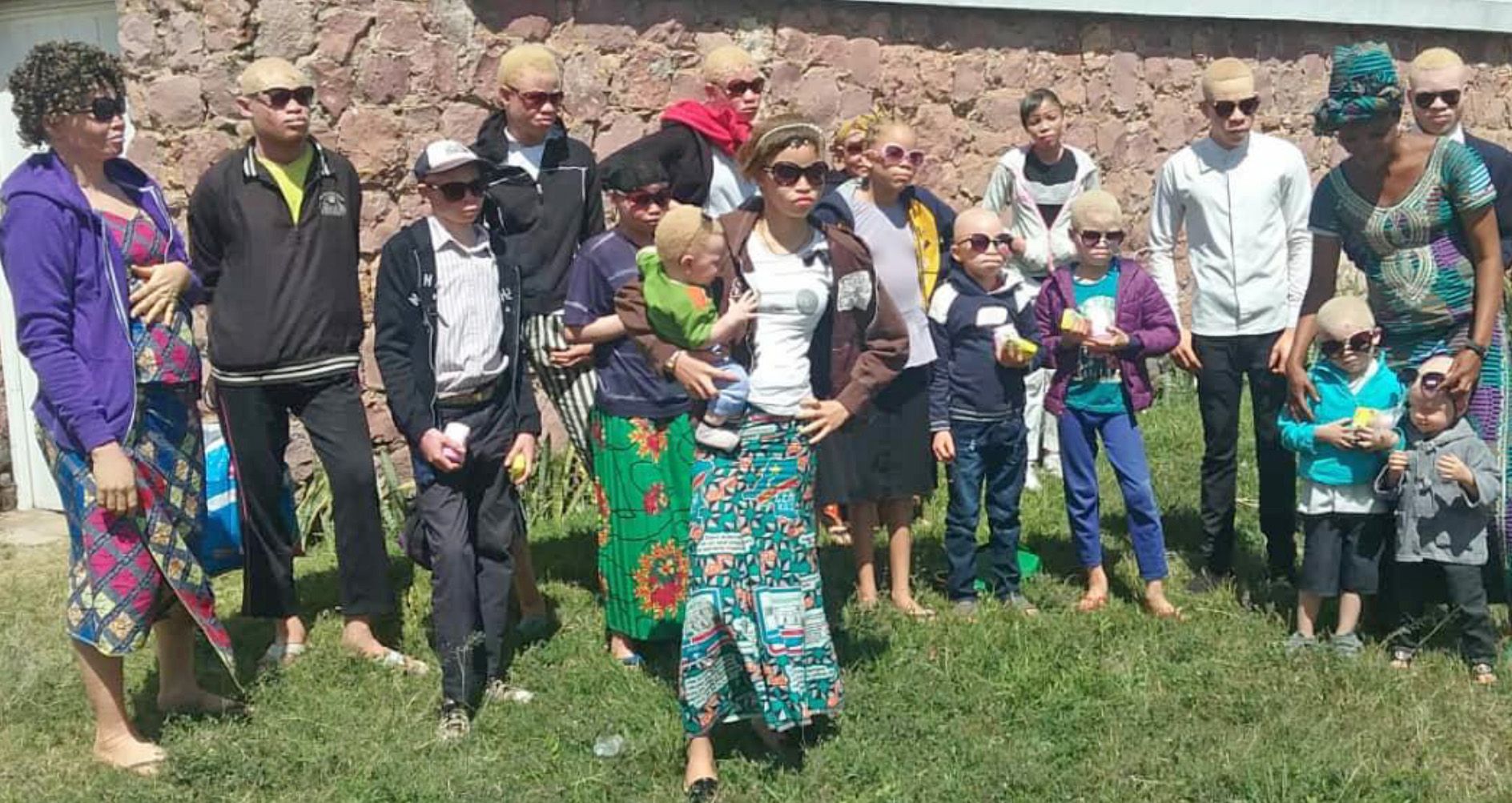 A group of people standing in the grass.